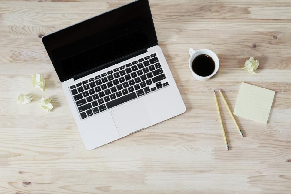 Laptop op een houten bureau met koffie