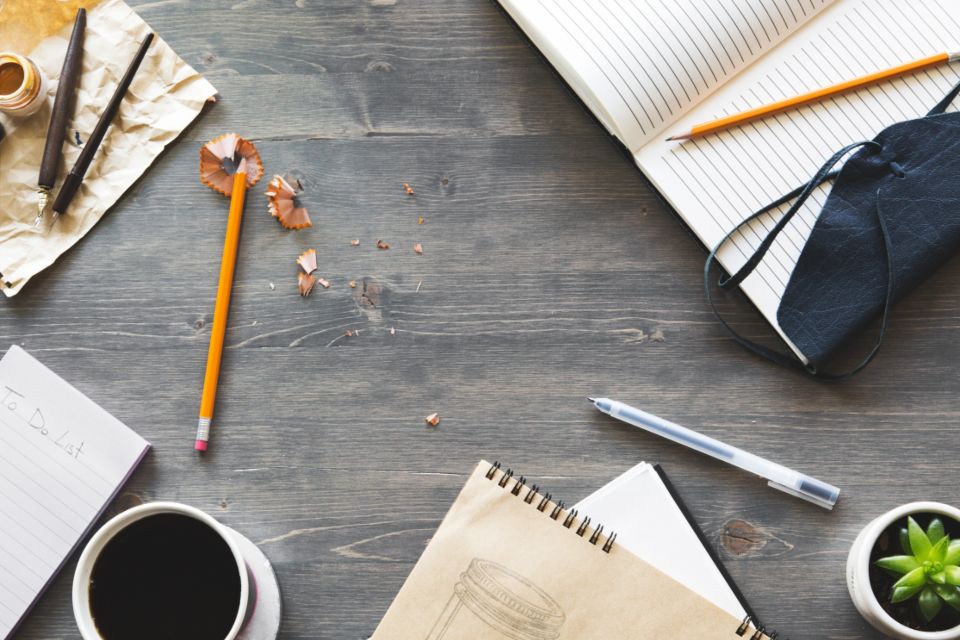 Houten bureau met notitieboeken, potlood en koffie